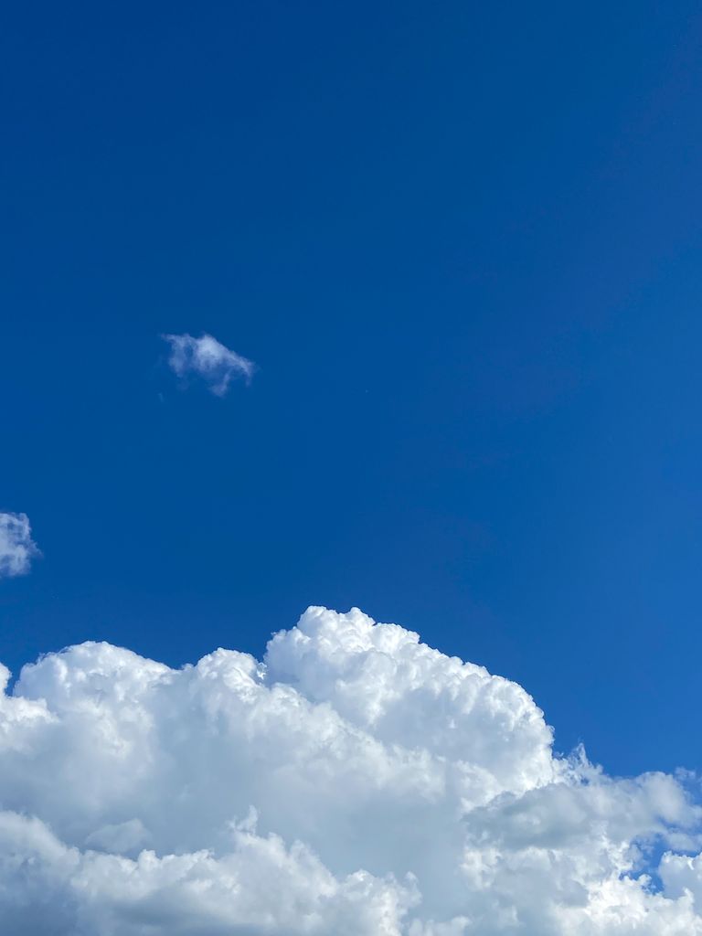 Cumulus clouds against a vivid blue sky, showcasing a serene and peaceful atmosphere.